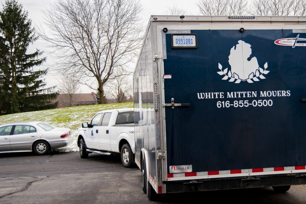 White Mitten Movers trailer attached to truck